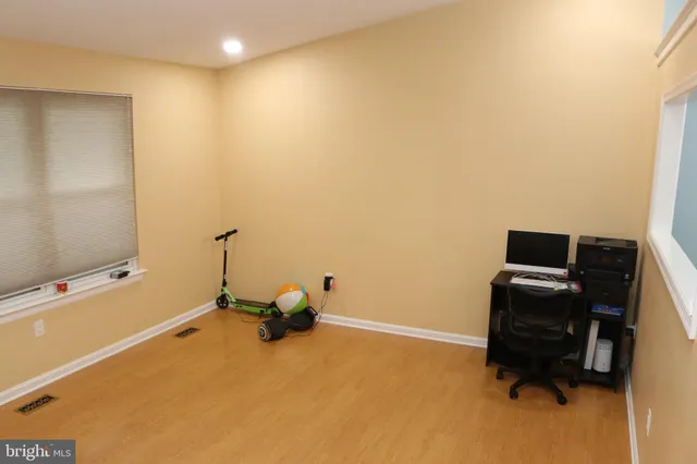 a room with gym equipment and wooden floor