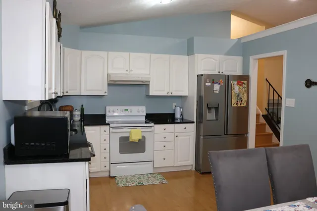 a kitchen with a refrigerator a stove top oven a sink and cabinets