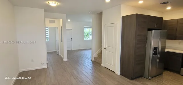 a view of a refrigerator in kitchen and wooden floor