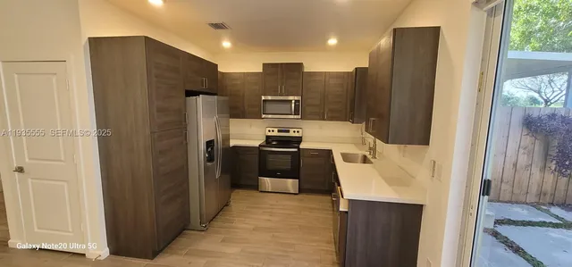 a kitchen with stainless steel appliances granite countertop a refrigerator and a stove