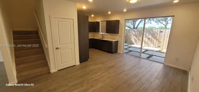 a view of a living room with hardwood floor and a large window