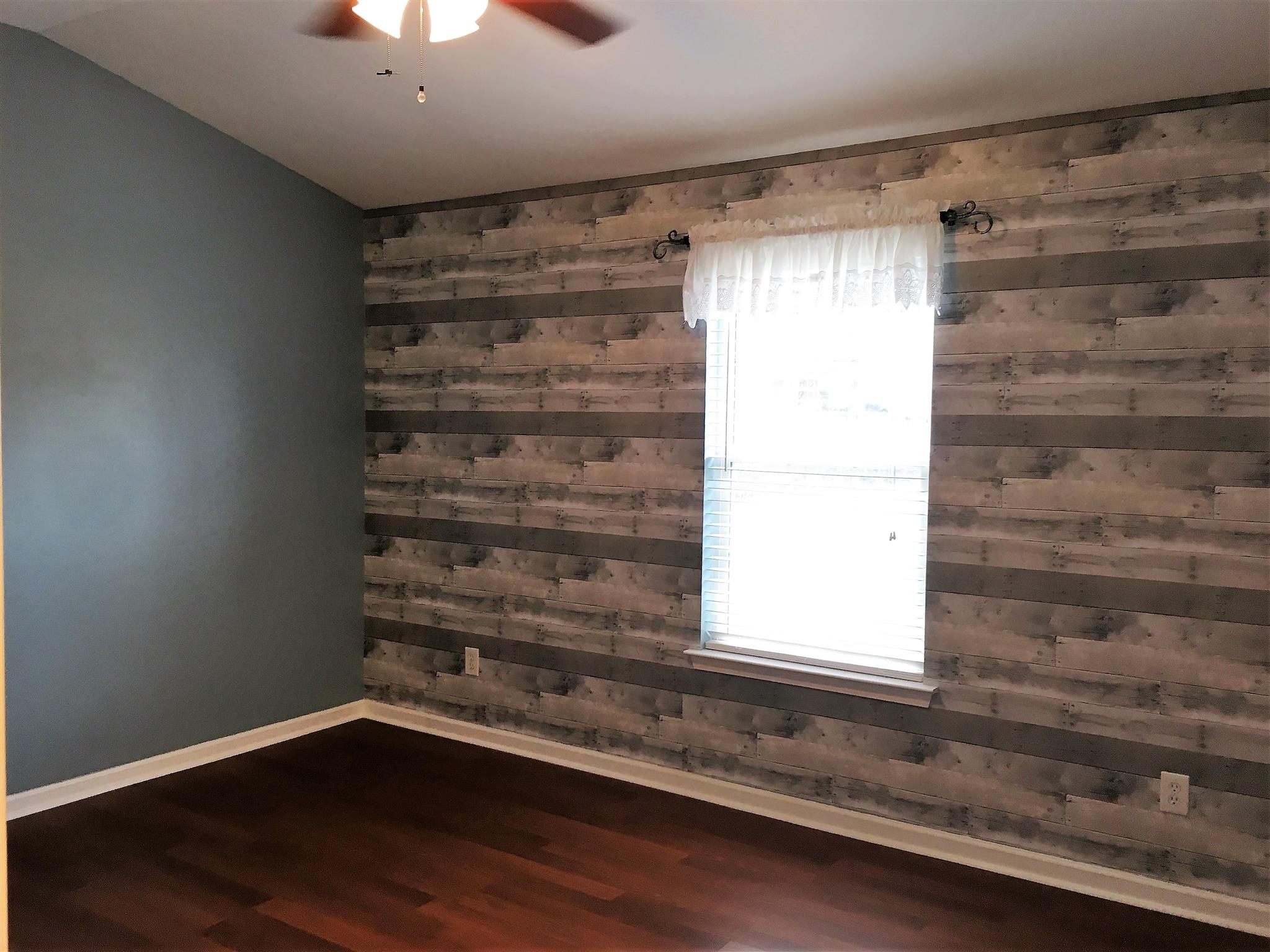 1101 Downs Boulevard, Unit A103 Franklin, TN 37064 - Photo 12 of 18 a view of empty room with wooden floor and fan
