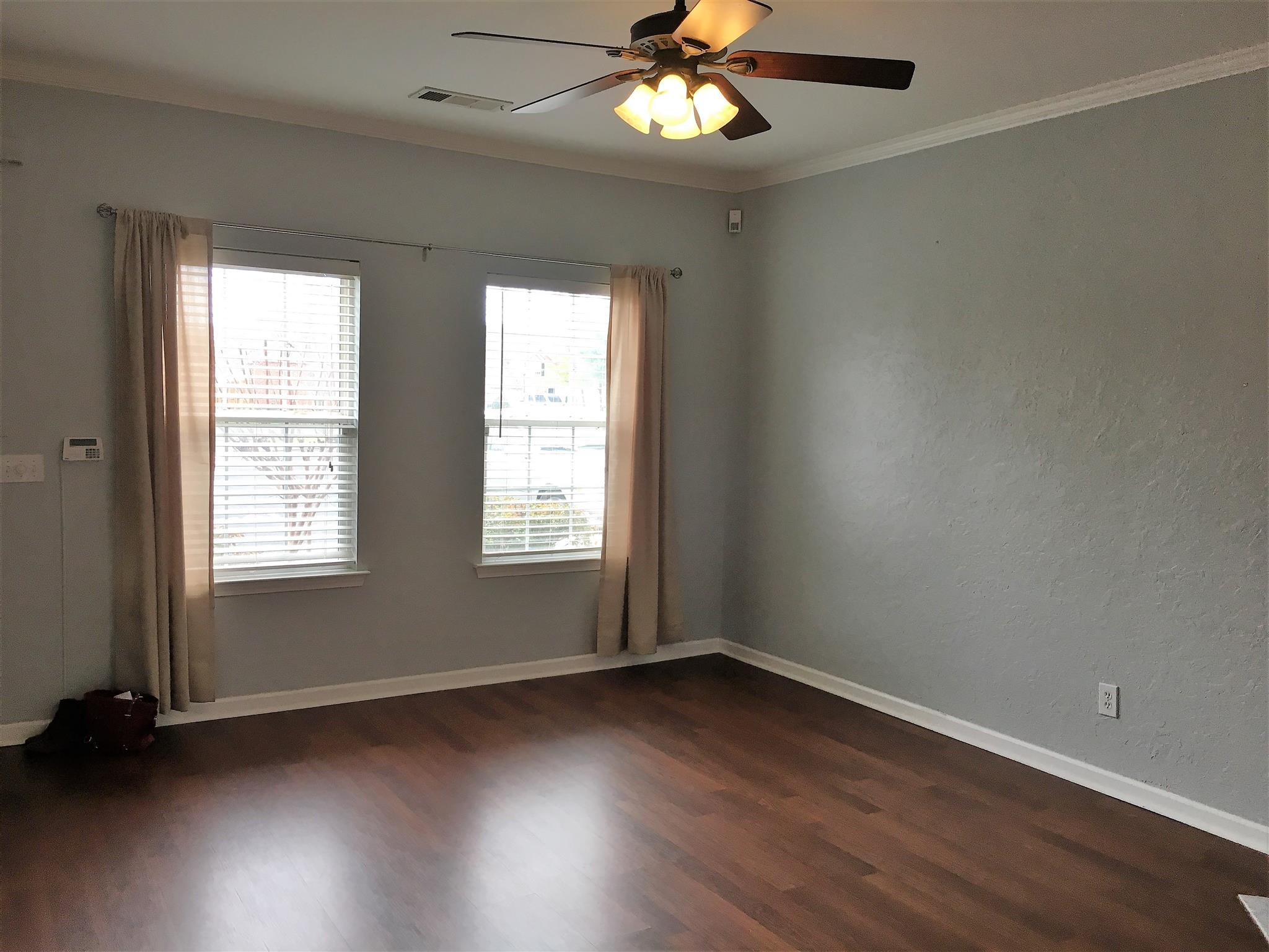 1101 Downs Boulevard, Unit A103 Franklin, TN 37064 - Photo 3 of 18 a view of an empty room with wooden floor and a window