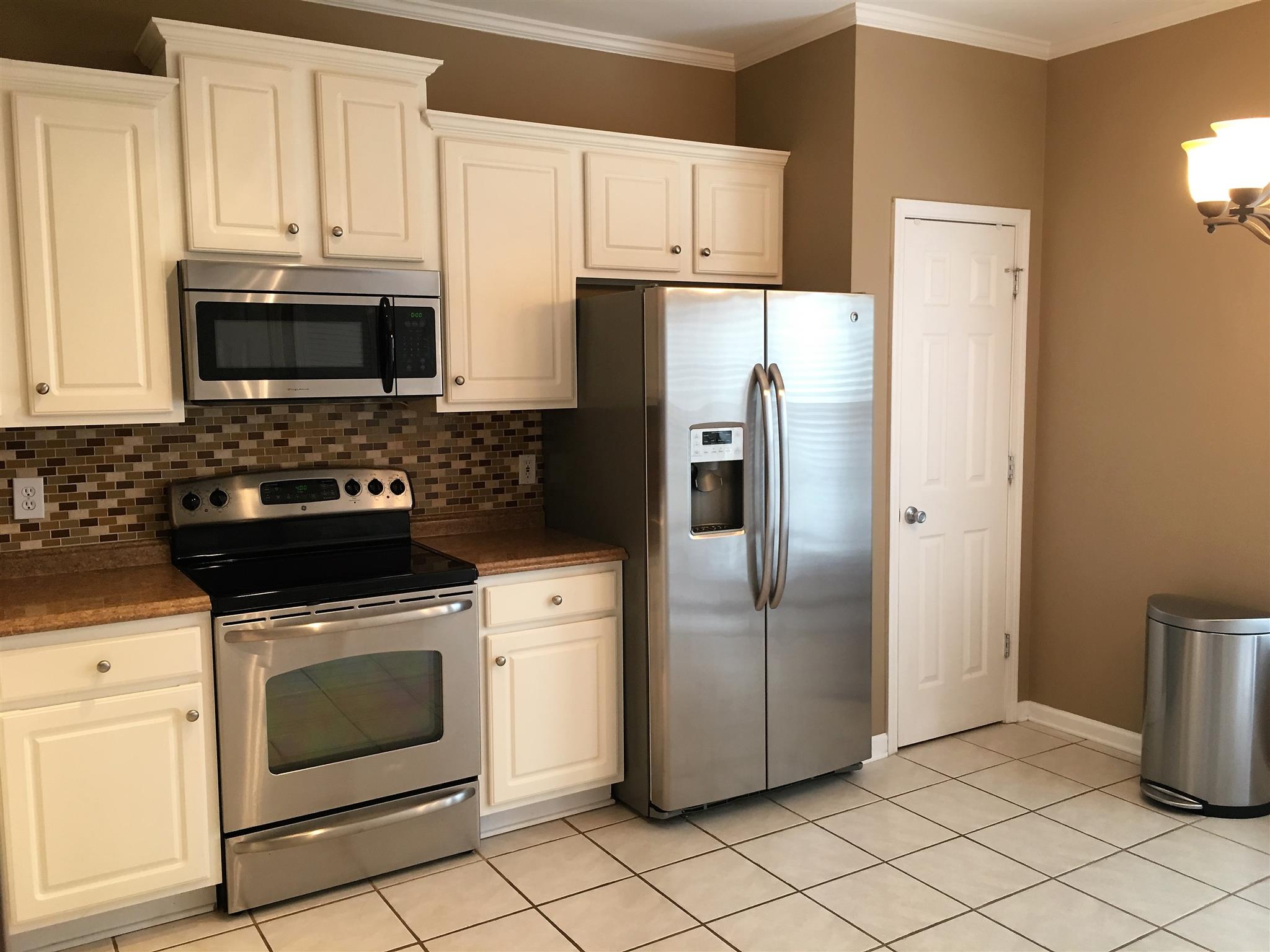 1101 Downs Boulevard, Unit A103 Franklin, TN 37064 - Photo 5 of 18 a kitchen with cabinets stainless steel appliances and a sink