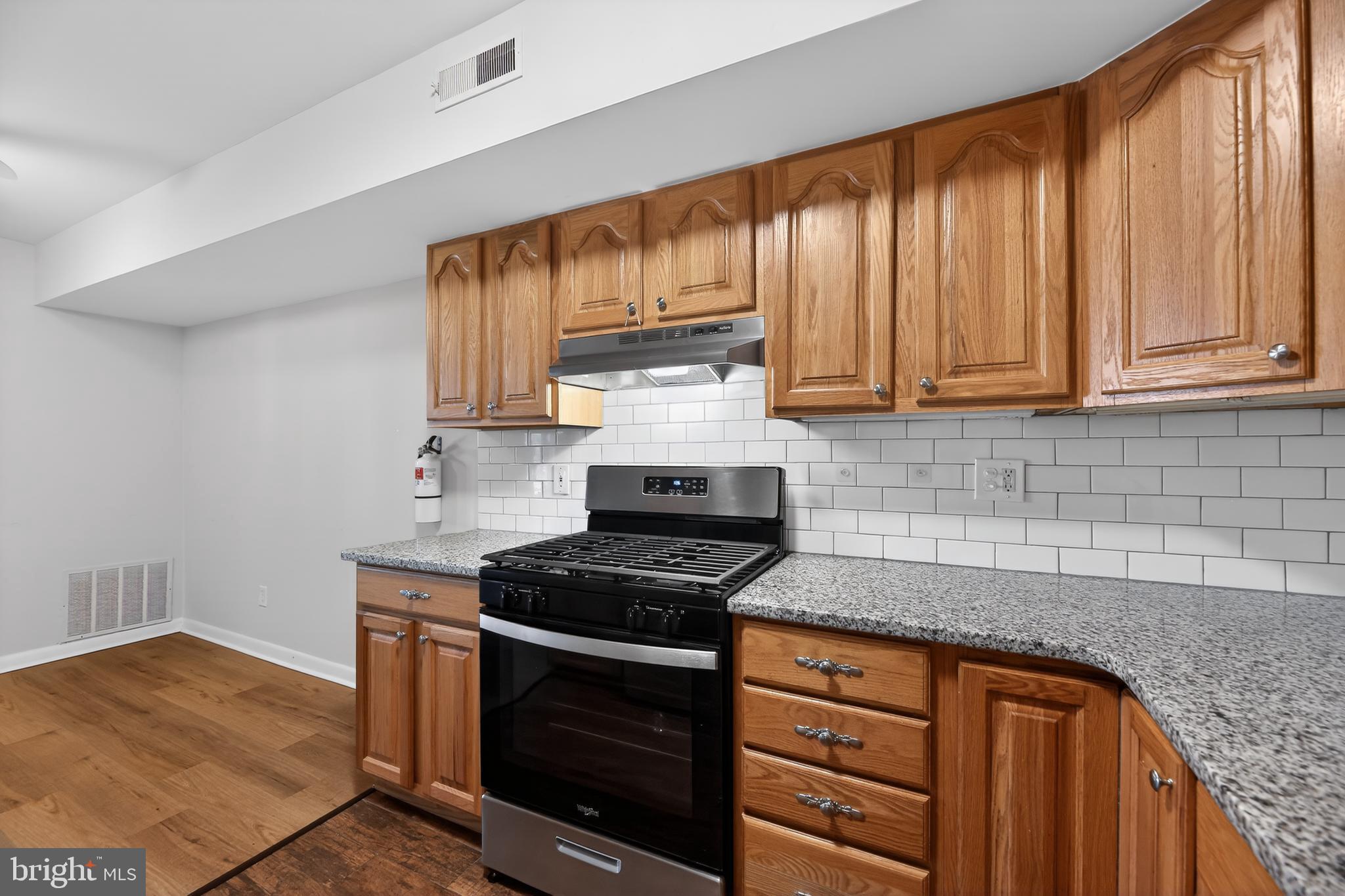 411 Stiles Avenue, Unit B11 Maple Shade, NJ 08052 - Photo 11 of 25 a kitchen with granite countertop wooden cabinets stainless steel appliances and a counter space