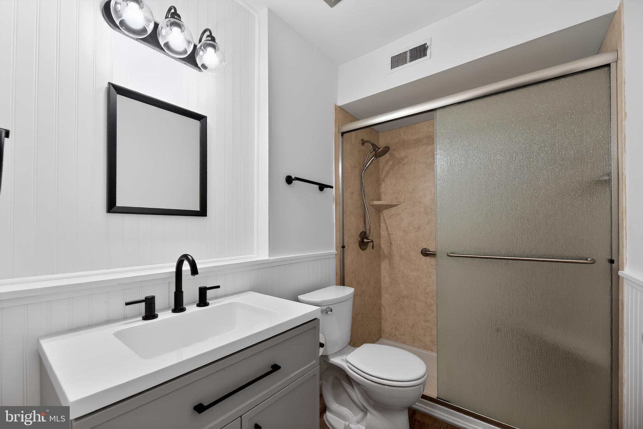 411 Stiles Avenue, Unit B11 Maple Shade, NJ 08052 - Photo 20 of 25 a bathroom with a sink a mirror a toilet and a shower