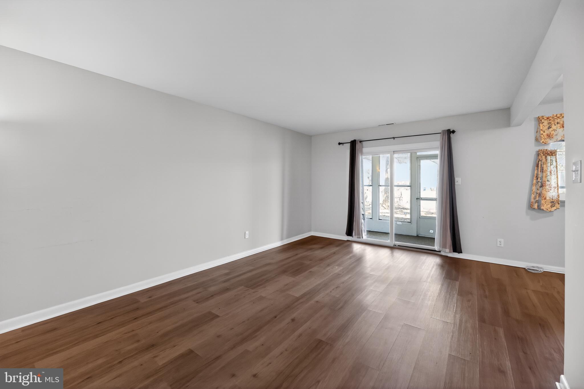 411 Stiles Avenue, Unit B11 Maple Shade, NJ 08052 - Photo 5 of 25 a view of an empty room with wooden floor and window