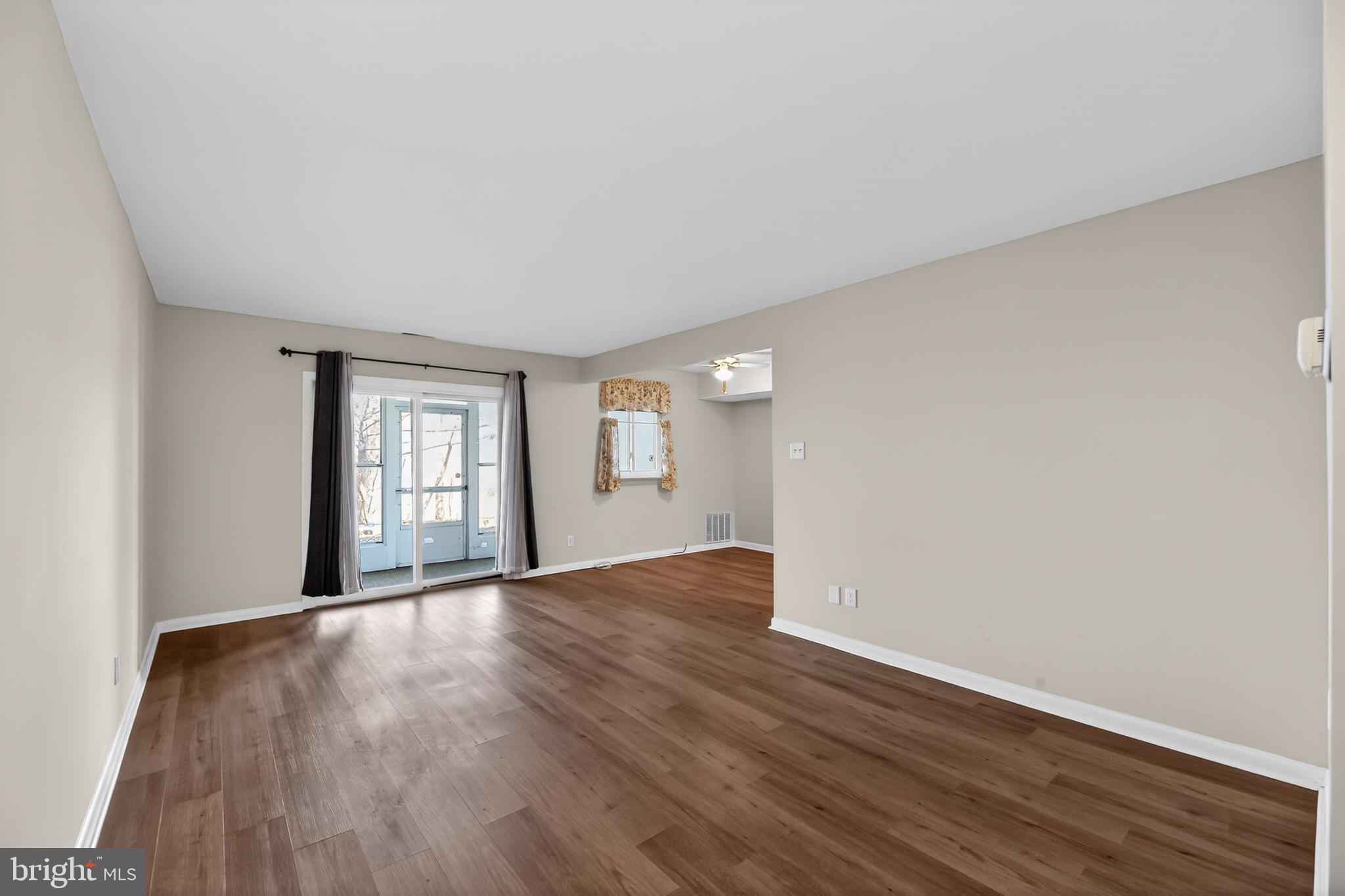 411 Stiles Avenue, Unit B11 Maple Shade, NJ 08052 - Photo 6 of 25 a view of an empty room with wooden floor and window