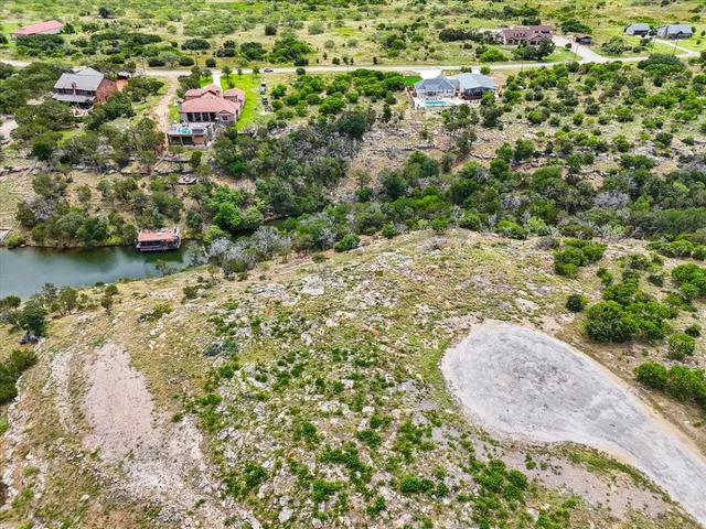 an aerial view of a house with a yard and lake view