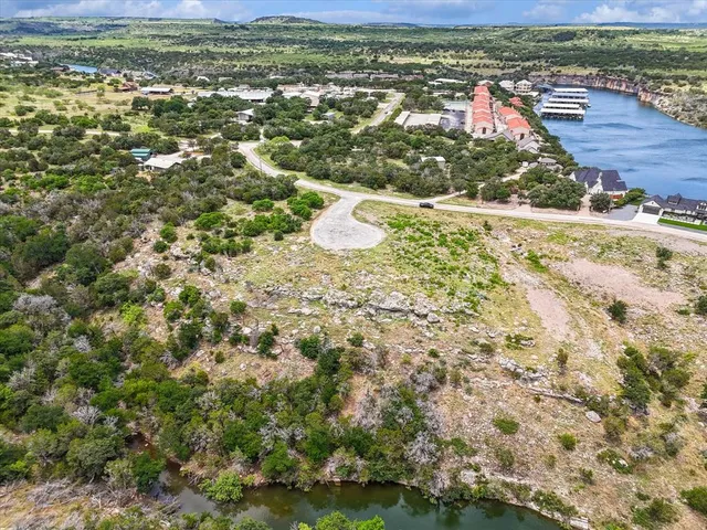an aerial view of residential houses with outdoor space and trees