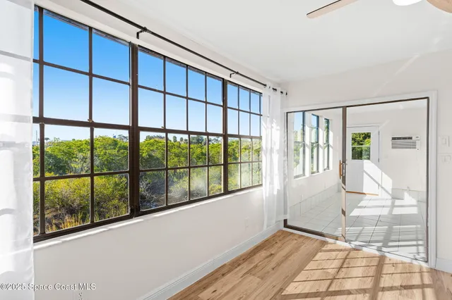a view of a hallway with wooden floor and a living room
