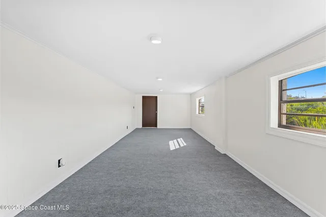 an aerial view of residential building with outdoor space and trees all around