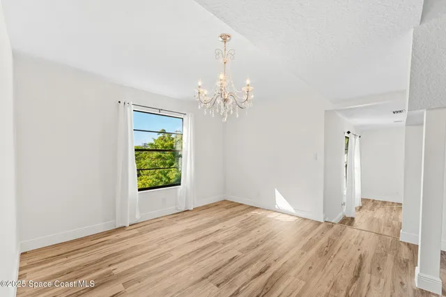 a view of a room with wooden floor and window