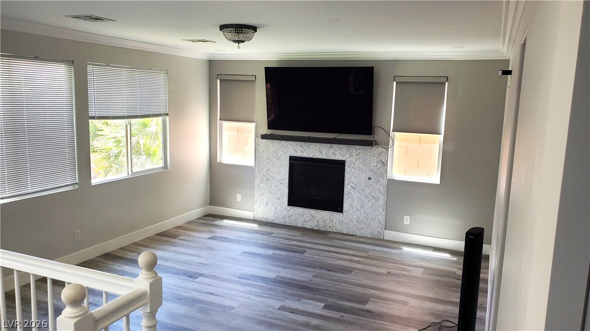 7903 Dell Ridge Avenue Las Vegas, NV 89179 - Photo 3 of 20 A refined living area boasts a sleek fireplace with a tiled surround, perfectly complemented by rich hardwood flooring.