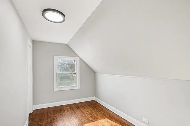 a view of a room with wooden floor and small window