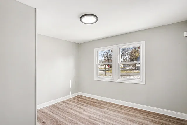 a view of a room with wooden floor and window