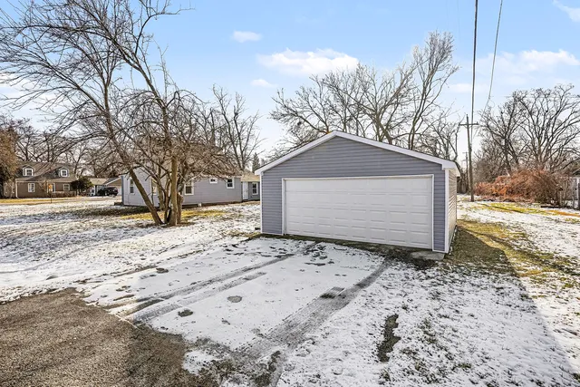 a front view of a house with a yard covered in snow