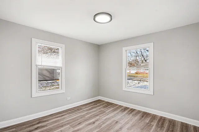 an empty room with windows and wall paintings