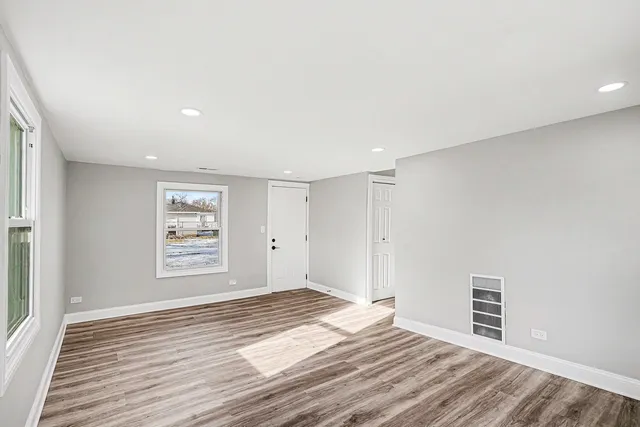 a view of empty room with wooden floor