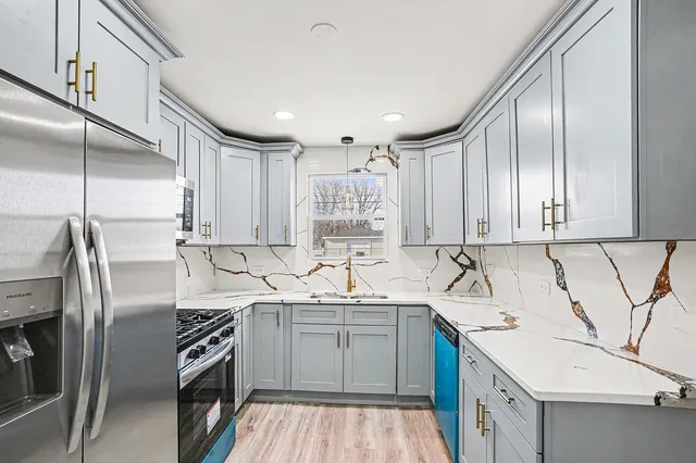 a kitchen with a sink cabinets stainless steel appliances and a counter top space