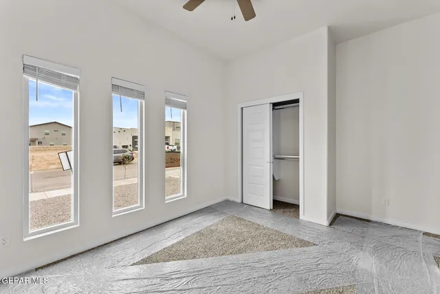 a view of an empty room with closet and a window