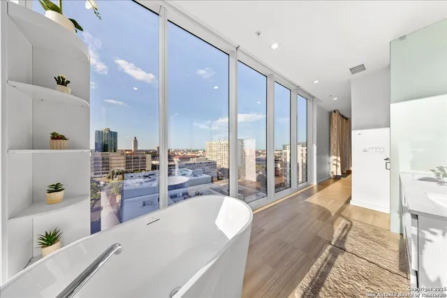 a large white kitchen with a large window and stainless steel appliances