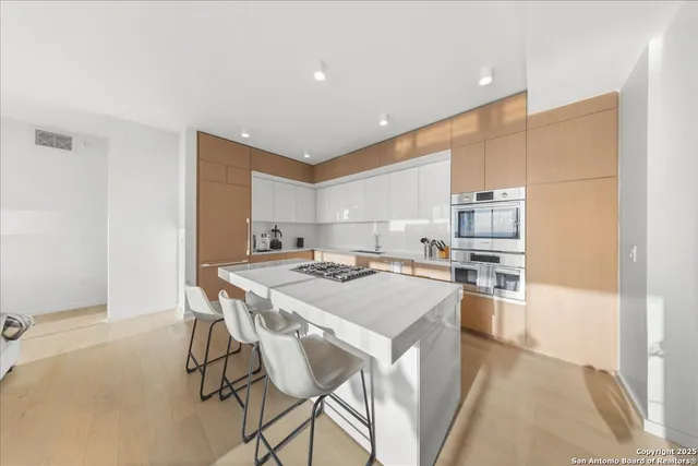 a kitchen with kitchen island a stove a table and chairs