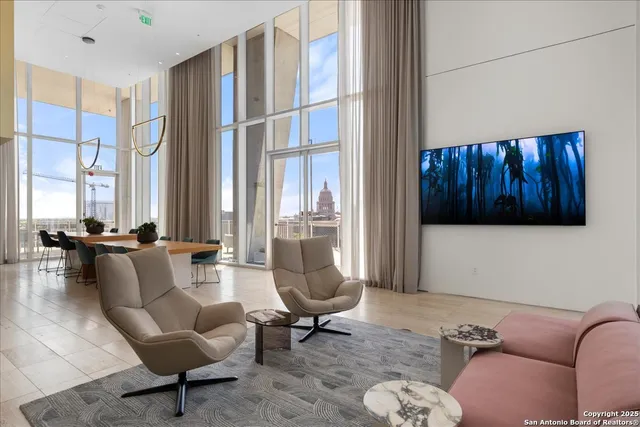 a living room with furniture fireplace and a large window