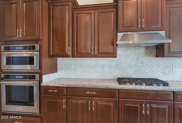 a kitchen with stainless steel appliances granite countertop a kitchen island a stove a sink and a refrigerator