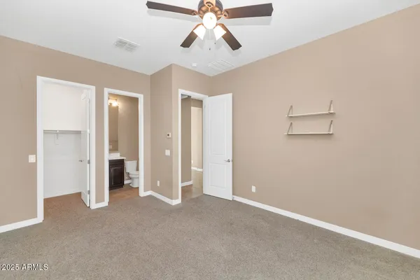 a hallway with granite countertop white cabinets and wooden floor