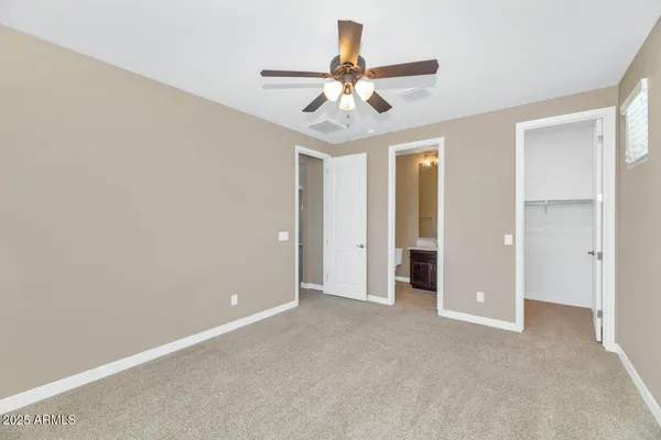 an empty room with window and ceiling fan