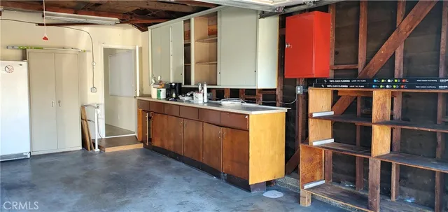 a kitchen with kitchen island granite countertop a sink and a refrigerator
