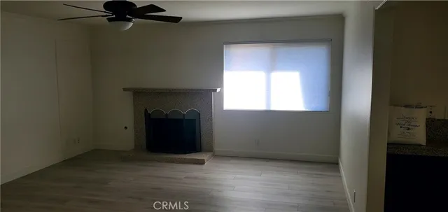 an empty room with a fireplace and windows