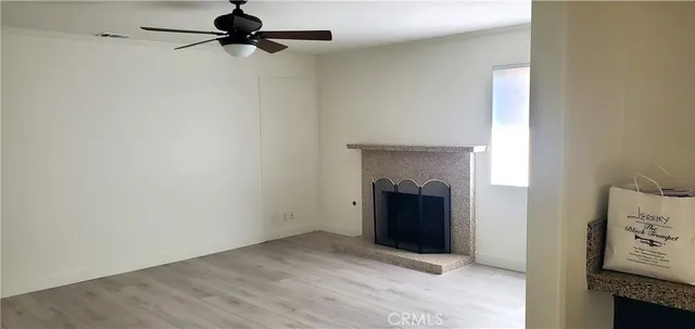 a view of an empty room with a fireplace and a window