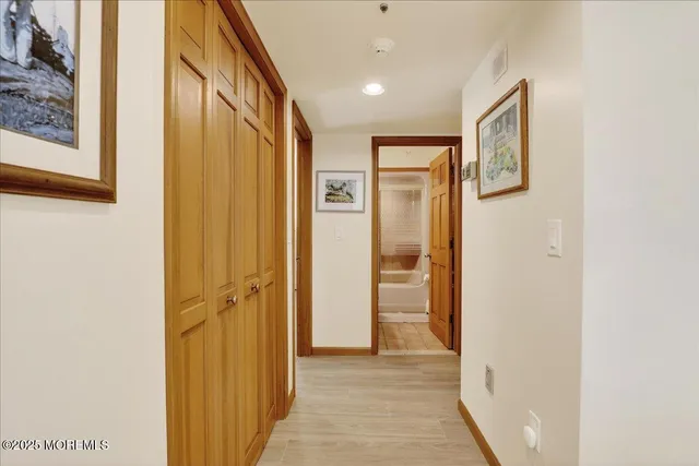 a view of a hallway with wooden floor and closet