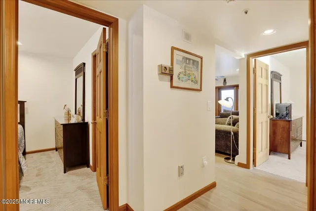 a view of a hallway with wooden floor and closet