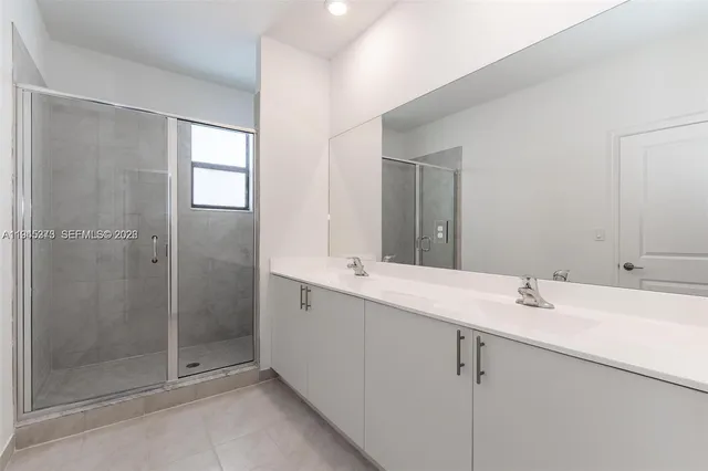 a bathroom with a shower sink and mirror
