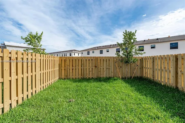 a view of a backyard with wooden fence
