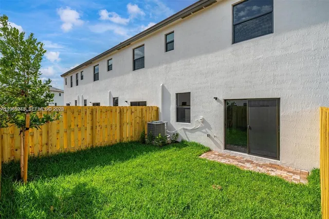 a view of backyard with barbeque grill and potted plants