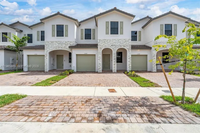 a front view of a house with a yard and a garage