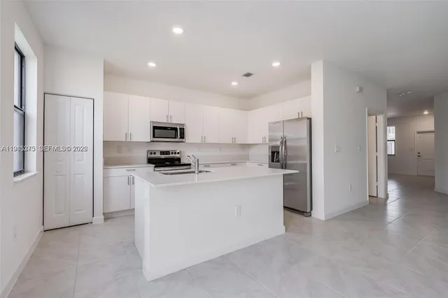 a kitchen with stainless steel appliances a refrigerator a stove top oven a sink and dishwasher