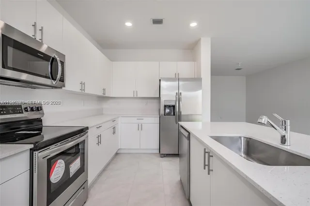 a kitchen with stainless steel appliances granite countertop a sink and a stove