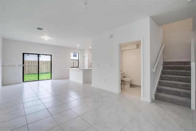 a view of an empty room with a fireplace and a window
