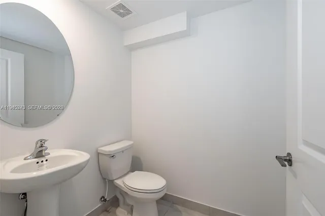a bathroom with a sink mirror and toilet