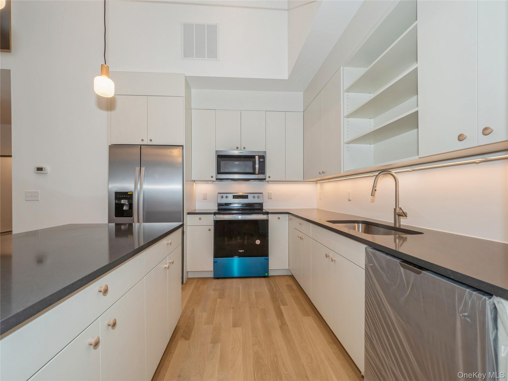 50 Old Albany Post Road North, Unit #1 Cold Spring, NY 10516 - Photo 9 of 18 a large kitchen with cabinets a sink and stainless steel appliances