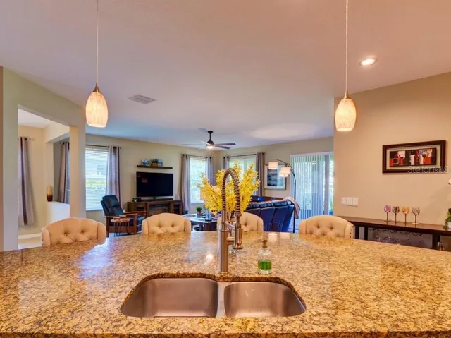 a kitchen with kitchen island granite countertop a sink and a large window