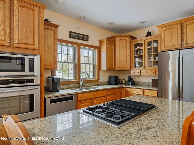 a kitchen with stainless steel appliances granite countertop a refrigerator a stove and a wooden floors
