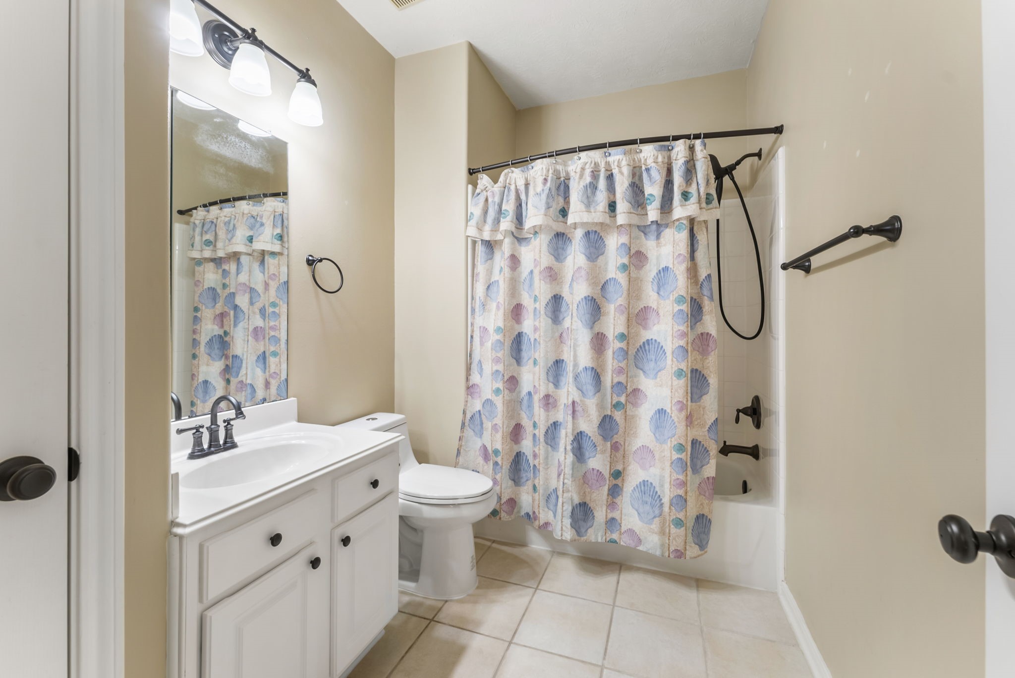 11 South Bendrook Loop Conroe, TX 77384 - Photo 19 of 27 a bathroom with a shower curtain and a sink