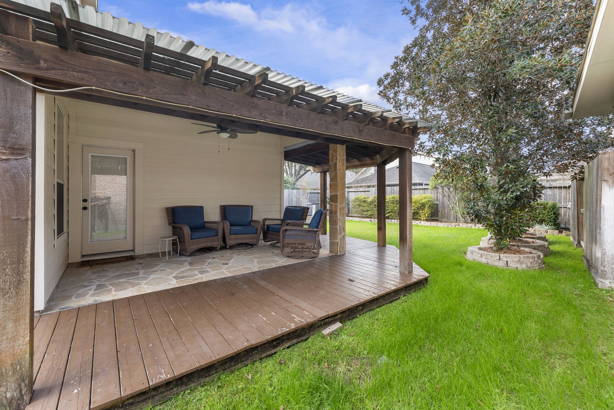 11 South Bendrook Loop Conroe, TX 77384 - Photo 22 of 27 a view of a patio with table and chairs potted plants and floor to ceiling window