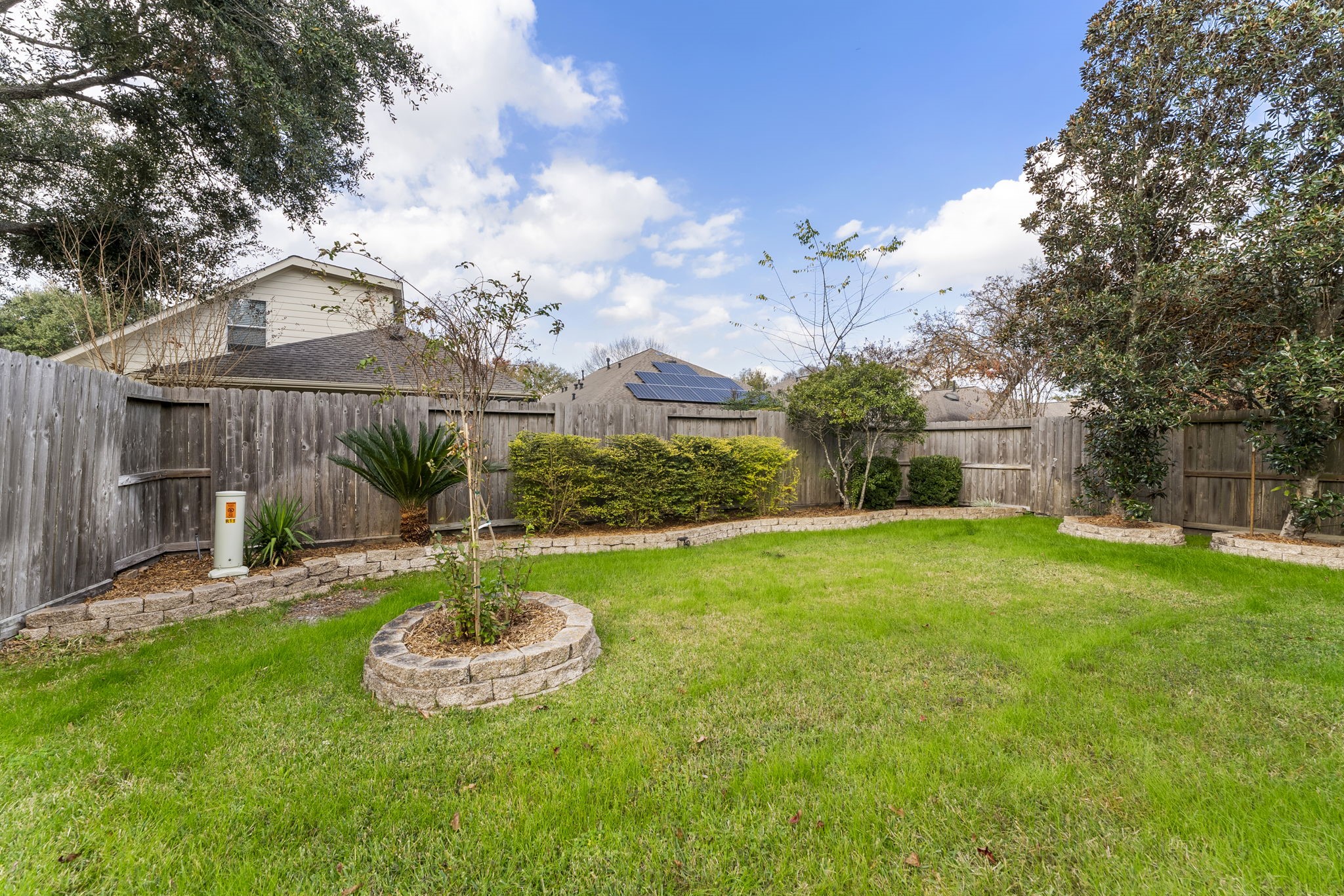 11 South Bendrook Loop Conroe, TX 77384 - Photo 24 of 27 a view of a backyard with table and chairs and wooden fence